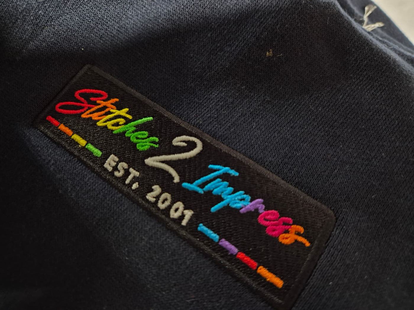 Close up of a rainbow embroidered logo patch